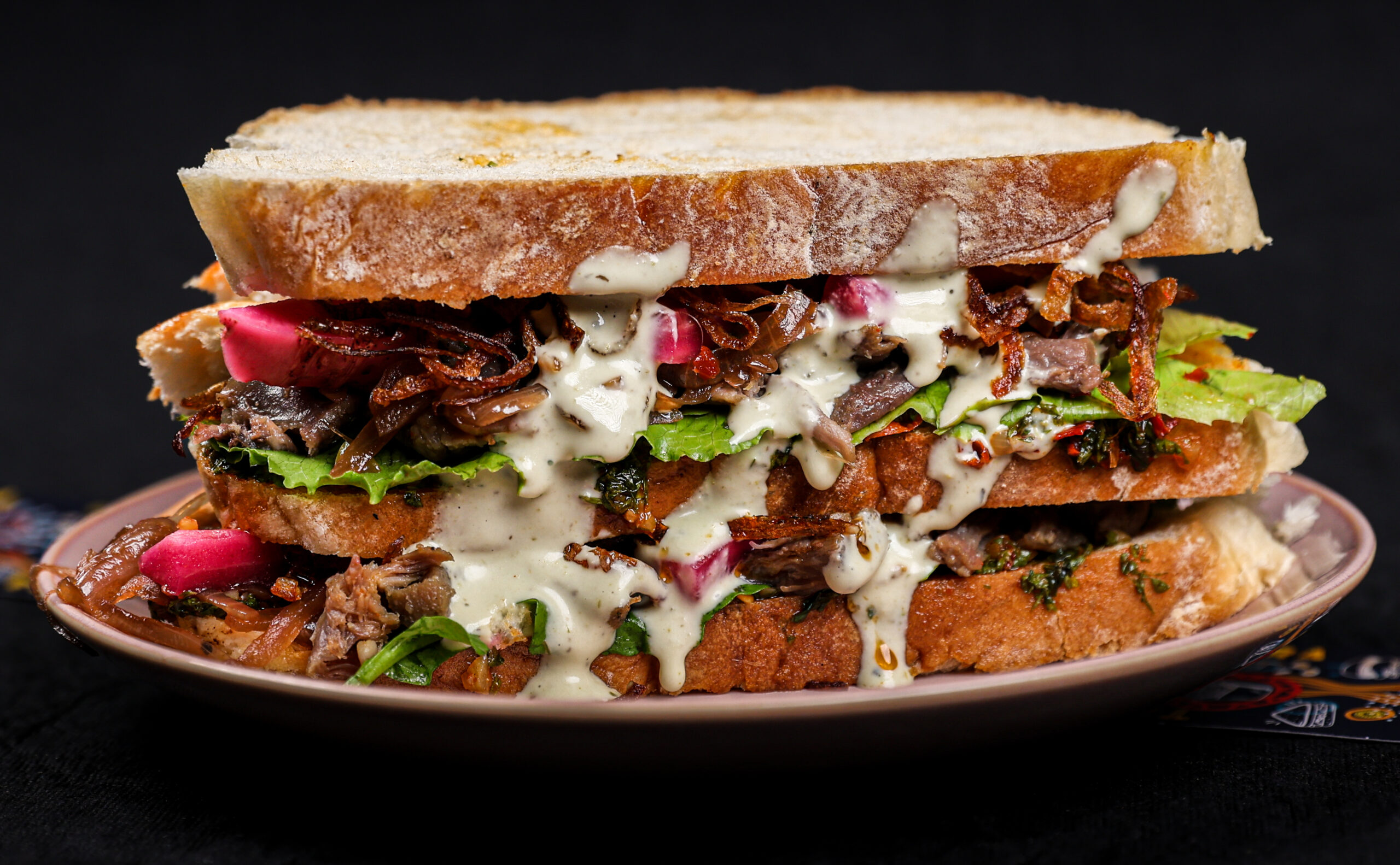 Chimmichuri Mutton Sandwich on Sourdough with pickled beetroot, caramelized onions and crispy onions – Tavora